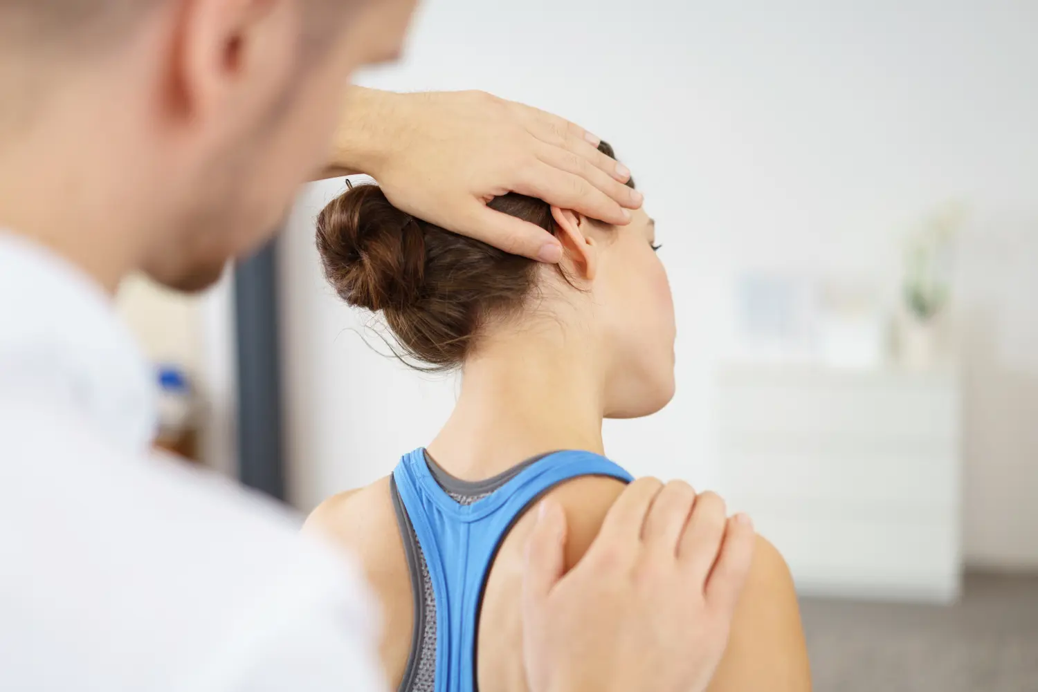 physiotherapeut behandelt eine patientin mit nackenschmerzen 